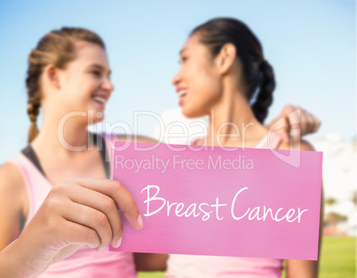 Breast cancer against two smiling women wearing pink for breast