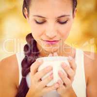 Composite image of pretty brunette having cup of tea