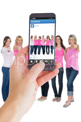 Composite image of female hand holding a smartphone