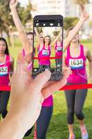 Composite image of female hand holding a smartphone