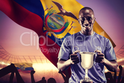 Composite image of portrait of happy athlete holding trophy
