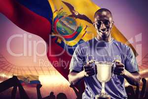 Composite image of portrait of happy athlete holding trophy