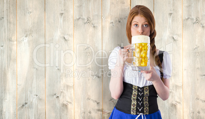 Composite image of oktoberfest girl drinking jug of beer