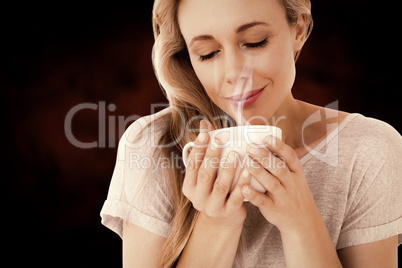 Composite image of smiling blonde with hot beverage relaxing