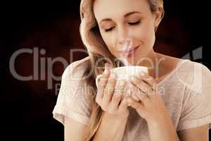 Composite image of smiling blonde with hot beverage relaxing