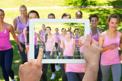 Composite image of hand holding tablet pc