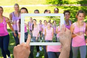 Composite image of hand holding tablet pc