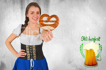 Composite image of pretty oktoberfest girl holding pretzel