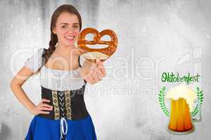 Composite image of pretty oktoberfest girl holding pretzel