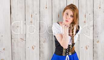 Composite image of oktoberfest girl blowing a kiss