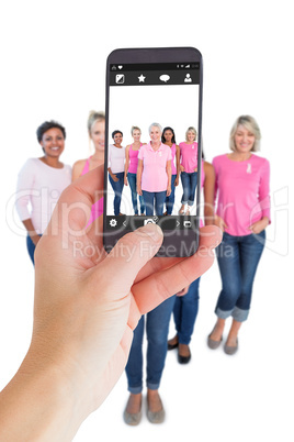 Composite image of female hand holding a smartphone