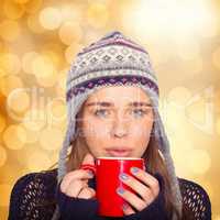 Composite image of beautiful woman in warm clothing drinking cof