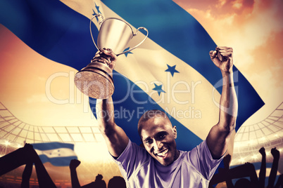 Composite image of portrait of happy sportsman cheering while ho