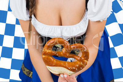 Composite image of oktoberfest girl bending and showing pretzel