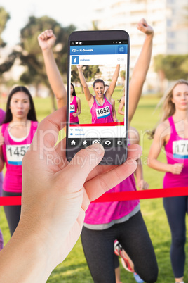 Composite image of female hand holding a smartphone