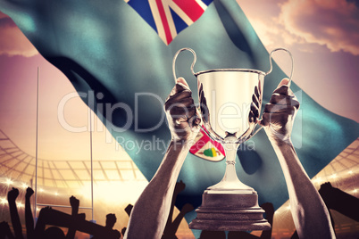 Composite image of cropped hand of athlete holding trophy