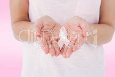 Composite image of woman holding pink ribbon for breast cancer a