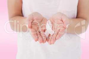 Composite image of woman holding pink ribbon for breast cancer a
