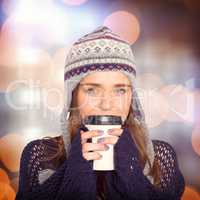 Composite image of beautiful woman in warm clothing drinking cof