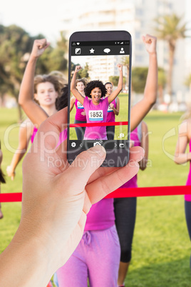 Composite image of female hand holding a smartphone