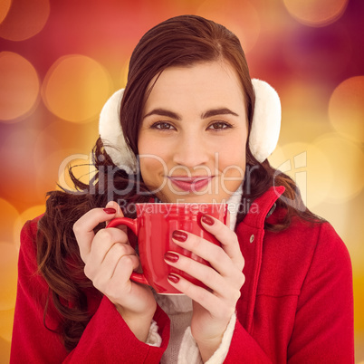 Composite image of woman in winter clothes enjoying a hot drink