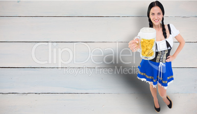 Composite image of pretty oktoberfest girl holding beer tankard