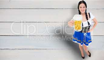 Composite image of pretty oktoberfest girl holding beer tankard