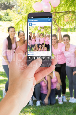 Composite image of female hand holding a smartphone