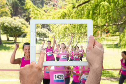 Composite image of hand holding tablet pc