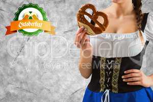 Composite image of pretty oktoberfest girl holding pretzel
