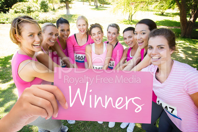 Winners against smiling women running for breast cancer awarenes