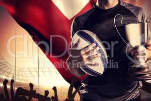 Composite image of midsection of successful rugby player holding