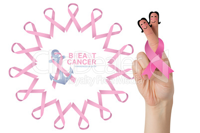 Composite image of crossed fingers with breast cancer ribbon