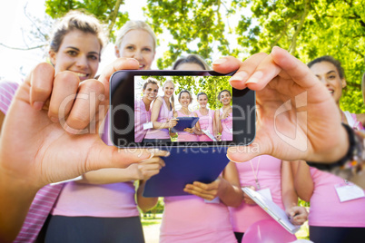 Composite image of hand holding smartphone showing