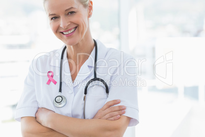 Composite image of happy doctor looking at camera with arms cros