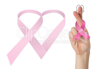 Composite image of crossed fingers with breast cancer ribbon