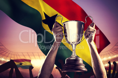 Composite image of successful rugby player holding trophy