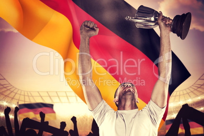 Composite image of happy rugby player holding trophy