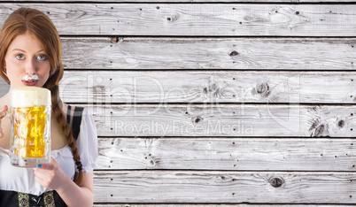 Composite image of oktoberfest girl drinking jug of beer