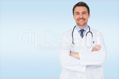 Composite image of handsome young doctor with arms crossed