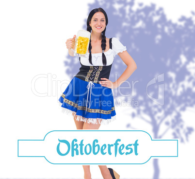 Composite image of pretty oktoberfest girl holding beer tankard