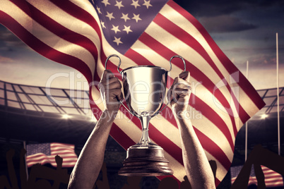 Composite image of successful rugby player holding trophy