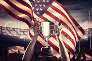 Composite image of successful rugby player holding trophy