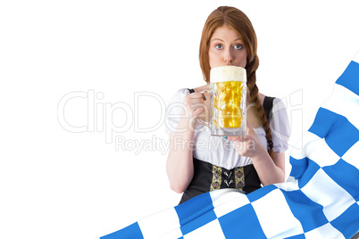 Composite image of oktoberfest girl drinking jug of beer