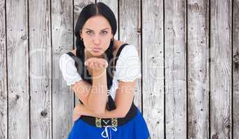 Composite image of pretty oktoberfest girl blowing a kiss