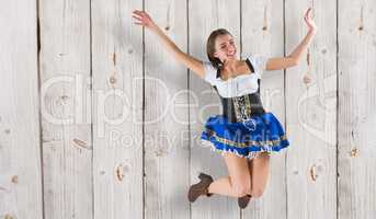 Composite image of pretty oktoberfest girl smiling and jumping