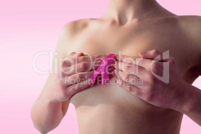 Composite image of nude woman with breast cancer ribbon