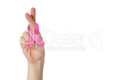 Crossed fingers with breast cancer ribbon