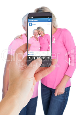 Composite image of female hand holding a smartphone