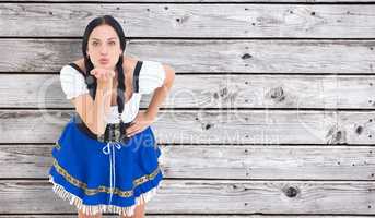 Composite image of pretty oktoberfest girl blowing a kiss